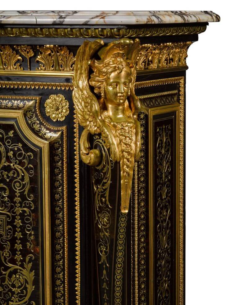 Close-up of ornate furniture featuring a gilded angel figure and luxurious marble top, showcasing intricate detailing.